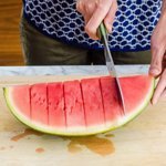 Cutting a quartered watermelon